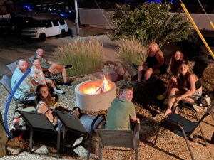 A family sitting around a fire pit cooking s'mores